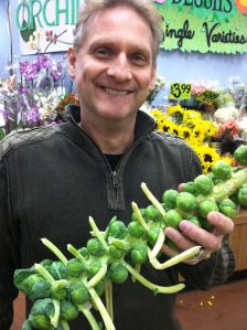 My husband holding a brussel sprout stalk